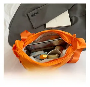 Interior storage capacity of the orange nylon crossbody bag showing compartments