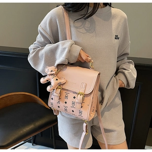 Detailed view of the cute pink teddy bear pattern and dual metallic buckle closure on the bag
