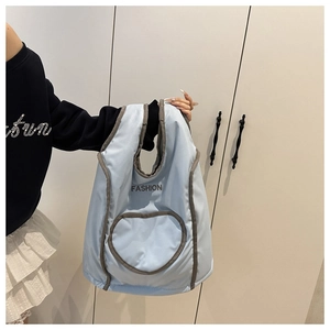 Detailed view of light blue quilted backpack with contrast grey trim and embroidered detail