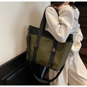 Detail of the olive green Oxford cloth tote bag with black straps and buckle closure