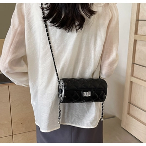 Detailed back view of a black quilted cylindrical crossbody bag with silver chain strap