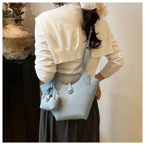 Detail view of water blue bucket bag with lychee grain texture and matching mini pouch