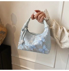 Détail du sac hobo bleu clair avec papillons en maille 3D et texture gaufrée