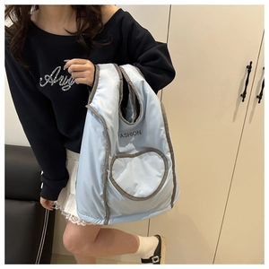 Detailed view of light blue quilted backpack with heart pocket and fashion embroidery