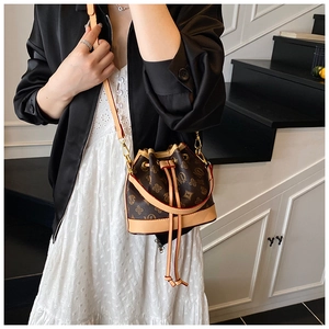 Detailed view of bucket bag featuring vintage monogram pattern and drawstring closure