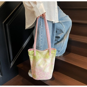 Detailed macro view of the jacquard floral pattern and green fabric label on canvas tote bag