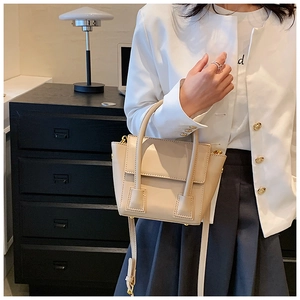Chic beige PU leather crossbody bag shown on model in a minimalist home setting