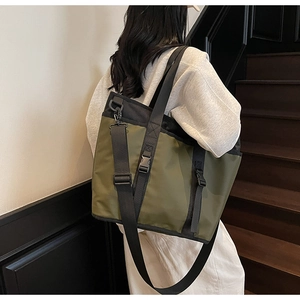 Detail of olive green nylon tote with adjustable black strap and sturdy plastic buckle
