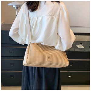 Detail of beige pleated shoulder bag with chic rectangular design and premium PU texture