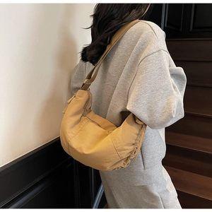 Khaki crescent dumpling bag shown on model for size and casual shoulder wear