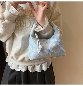 Détail du sac à main bleu clair en jacquard avec papillons 3D et motif floral