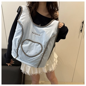 Close-up of light blue quilted tote bag with heart embroidery and Fashion text detail