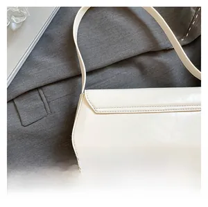 Close-up of premium white matte leather texture on a minimalist shoulder bag