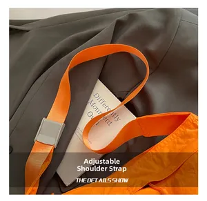 Close-up of bright orange nylon strap with grey adjustable plastic buckle detail
