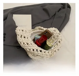 Detail view of woven shoulder bag showing internal capacity with phone and cosmetics