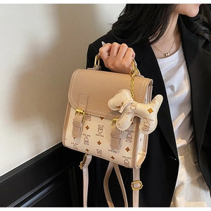 Detail of a beige PU leather crossbody bag featuring a cute cartoon bear and puppy charm