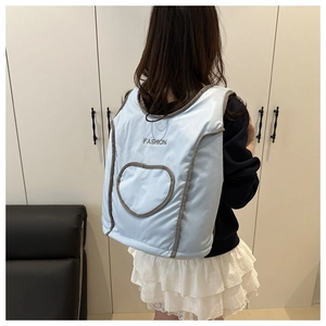 Rear view of a light blue padded vest featuring FASHION embroidery and a heart pattern