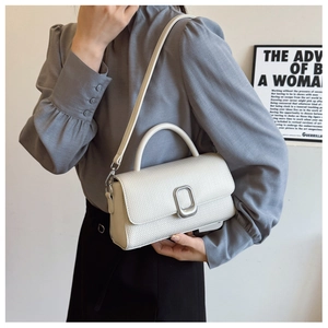 Detailed macro view of cream structured handbag with woven texture and silver metal lock