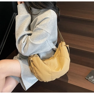 Detail of minimalist khaki crescent crossbody bag with durable canvas fabric texture