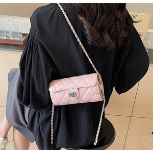 Détails du sac cylindre rose avec matelassage, fermoir doré et bandoulière chaîne