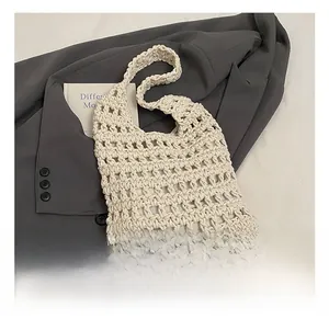 Detailed grid texture of handmade off-white woven hollow shoulder bag in bohemian style