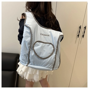 Detail of light blue quilted backpack with heart patch and fashion embroidery