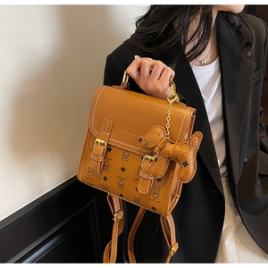 Close-up of brown teddy bear pattern backpack with leather texture and gold hardware details