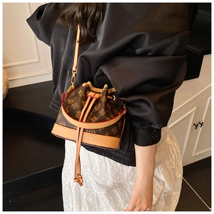 Detail of vintage bucket bag with monogram pattern and light brown leather trim