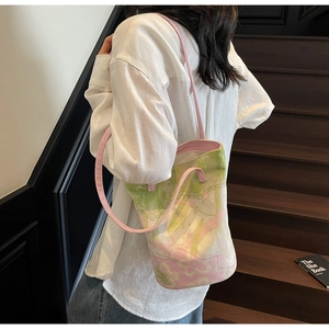 Detail of floral canvas bucket bag with pink and green abstract pattern on white shirt