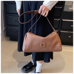 Detail showing vintage brown pleated texture and geometric buckle on a crossbody bag