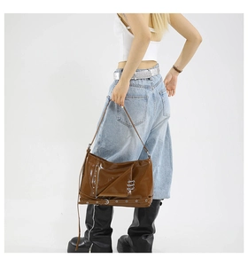 Brown glossy tote bag with silver rivets and buckle details in Y2K retro style