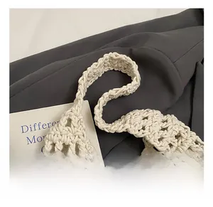 Detail of beige hand-woven tote bag showing hollow mesh pattern and soft knit strap
