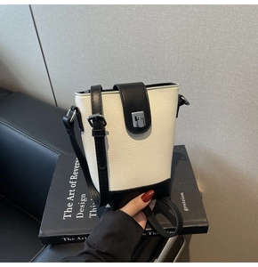 Detail of minimalist bucket bag with black and white color blocking and silver metal lock
