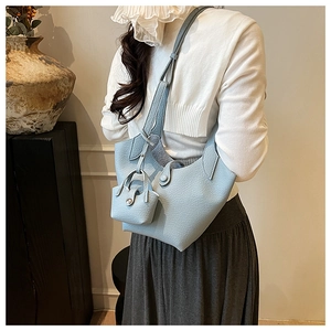Light blue lychee texture bucket bag detail with matching small pouch on a model