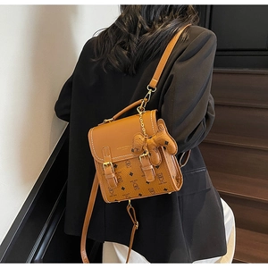 Detail of brown faux leather mini backpack with Lucky Bear pattern and bear charm