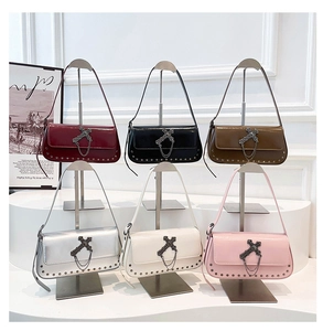 Macro shot of gothic cross metal buckles and rivet details on stylish crossbody bags