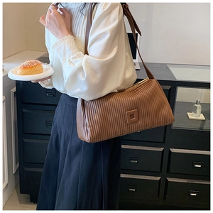 Detailed view of brown pleated faux leather texture on a retro rectangle baguette bag