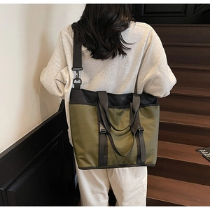 Close-up of olive green oxford tote bag with black straps on a luxury staircase