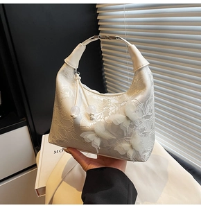 Détail de la texture en dentelle et papillons 3D sur un sac à main blanc élégant