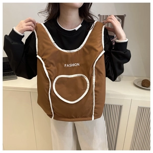 Detail of brown quilted vest with heart pocket and fashion text on a model