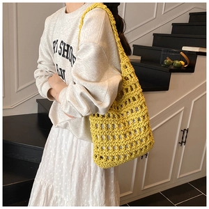 Detail of the vibrant yellow hand-woven crochet hollow grid pattern on the tote bag