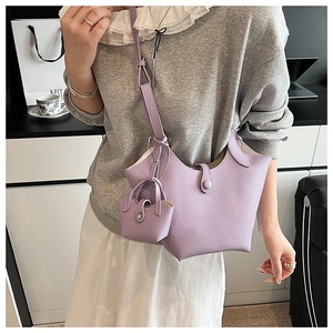 Close-up of lavender bucket bag in lychee pattern leather with matching mini pouch charm