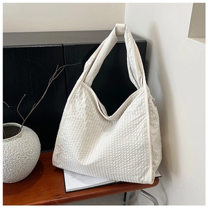 Detail shot of off-white waffle texture canvas tote bag with a wide shoulder strap