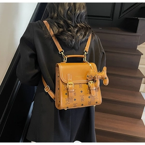 Detailed view of the brown teddy bear patterned backpack with stylish metallic buckles