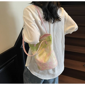 Detail of floral canvas tote bag with pink leather straps worn on a casual outfit