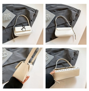 Detail view of cream PU leather baguette bag with metal cross chain and studded trim