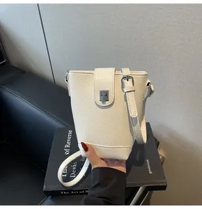 Close-up of off-white bucket bag with lychee grain leather and silver metal clasp