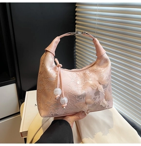 Detail of pink handbag featuring 3D butterfly appliqués and intricate lace embroidery