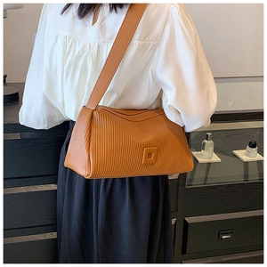 Detailed view of the brown shoulder bag's vertical pleated texture and soft leather