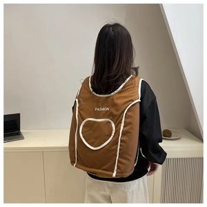 Detail of brown vintage backpack featuring heart stitching and white trim details